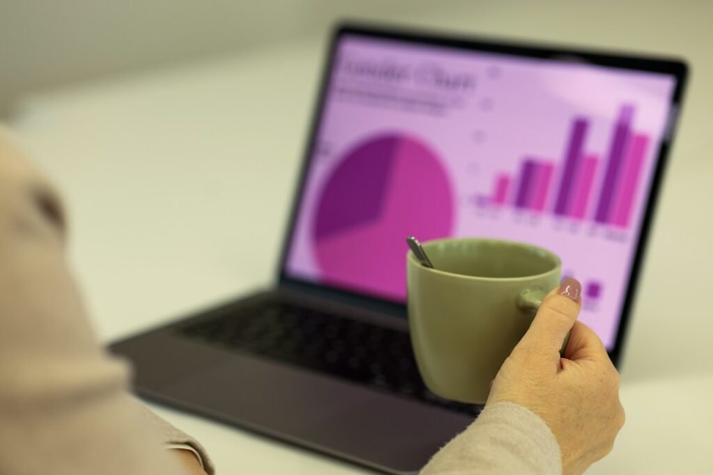 Small business owner working at a laptop while reviewing a chart, illustrating business workflow automation