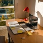 Writer using a laptop at a desk to draft and edit an article with AI writing assistance