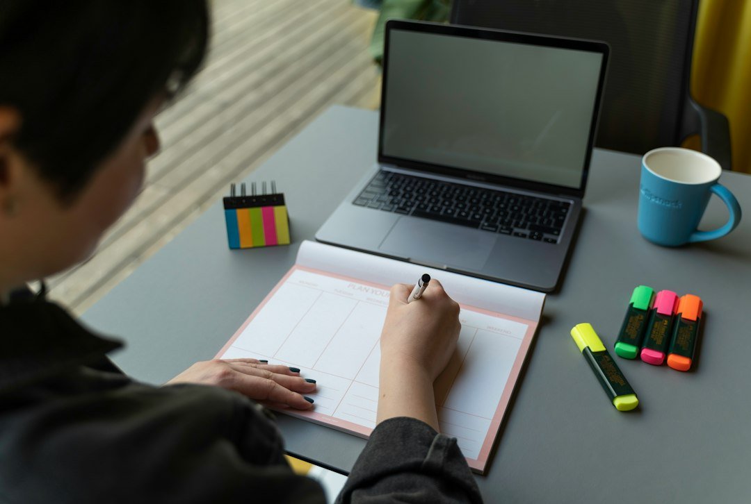 Notebook and planner on a desk beside a laptop, ready for organizing meeting action items